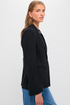 Young woman models the Midnight Boy Blazer, a classic, oversized one-button blazer with a peak lapel, exuding effortless, high-end style through its drapey wool crepe fabric.