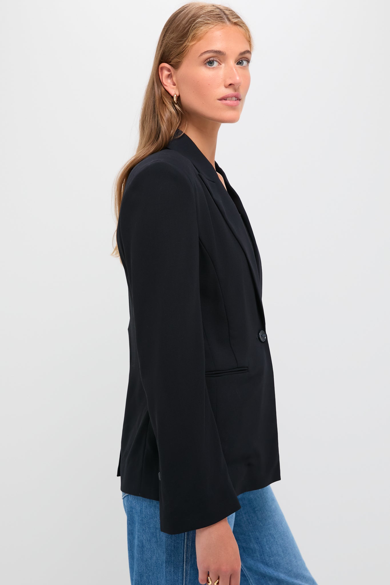 Young woman models the Midnight Boy Blazer, a classic, oversized one-button blazer with a peak lapel, exuding effortless, high-end style through its drapey wool crepe fabric.