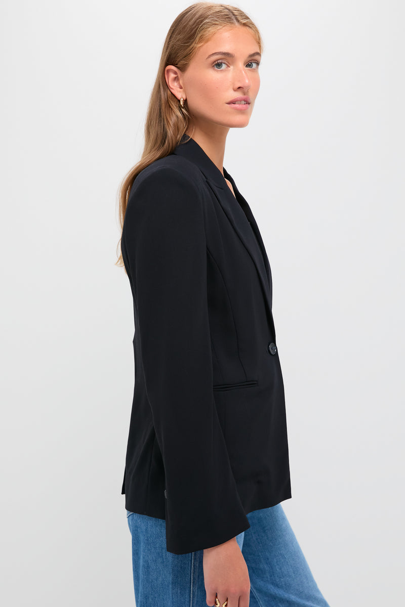 Young woman models the Midnight Boy Blazer, a classic, oversized one-button blazer with a peak lapel, exuding effortless, high-end style through its drapey wool crepe fabric.