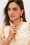 Young woman in a classic, high-end Tan & Cream Embroidery Louisa Blouse with a ruffled collar and floral embroidery, exuding effortless, fun elegance.