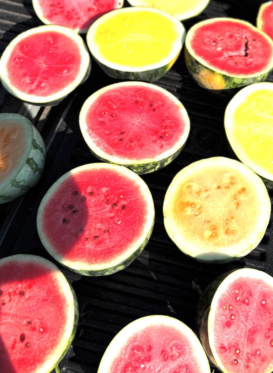 Watermelons split in half in a truck bed. 