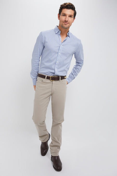 A man models the classic Light Blue Gingham Movement Shirt, tucked into beige chinos. Effortless and high-end, perfect for versatile, fun adventures.