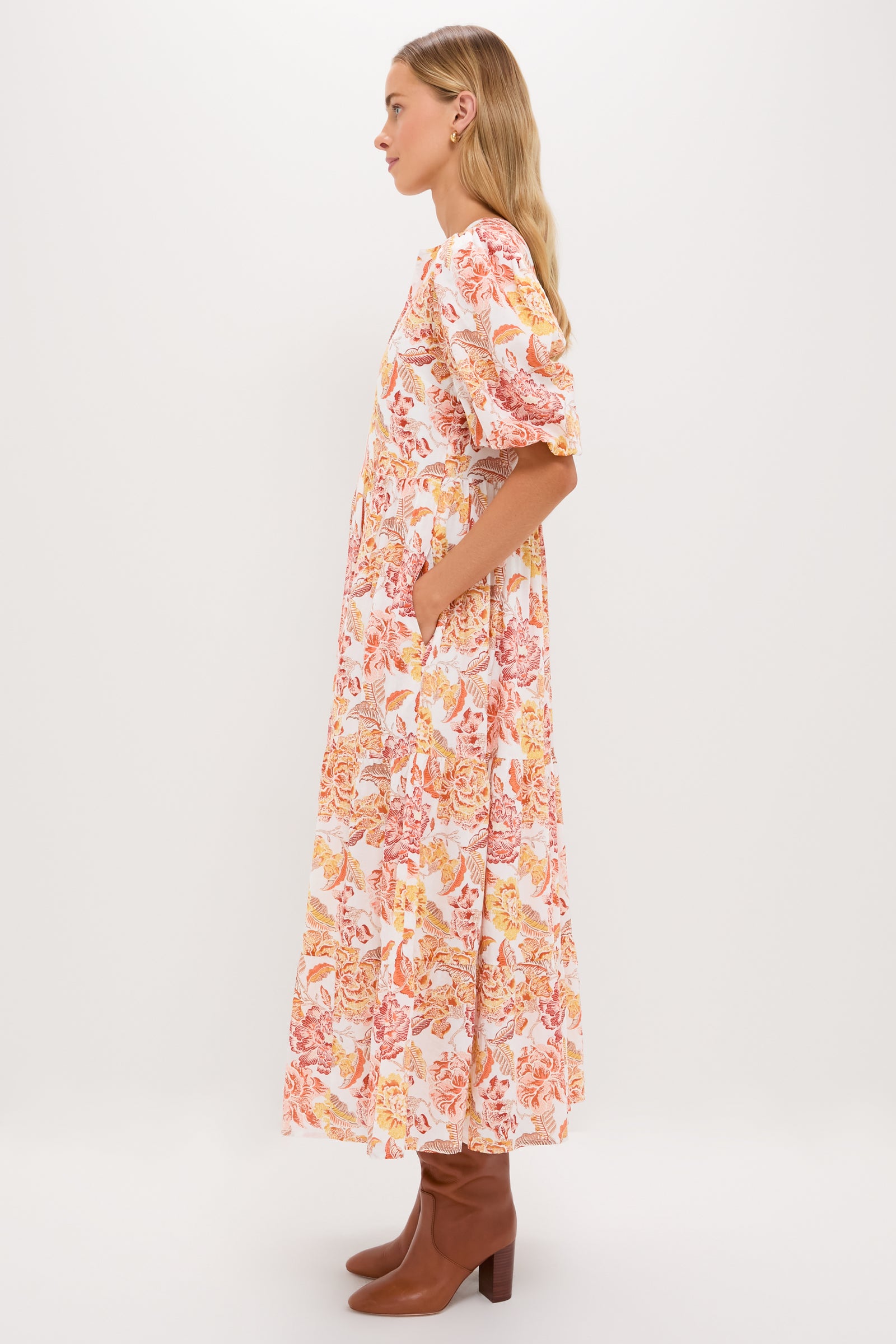 Saffron Floral Cisco Maxi Dress: A classic, effortless tiered dress with puff sleeves and floral print, styled with brown boots for a fun, high-end look.