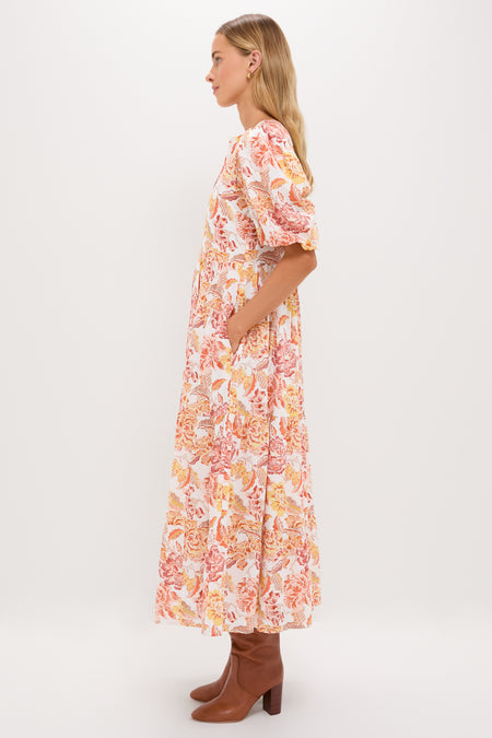 Saffron Floral Cisco Maxi Dress: A classic, effortless tiered dress with puff sleeves and floral print, styled with brown boots for a fun, high-end look.