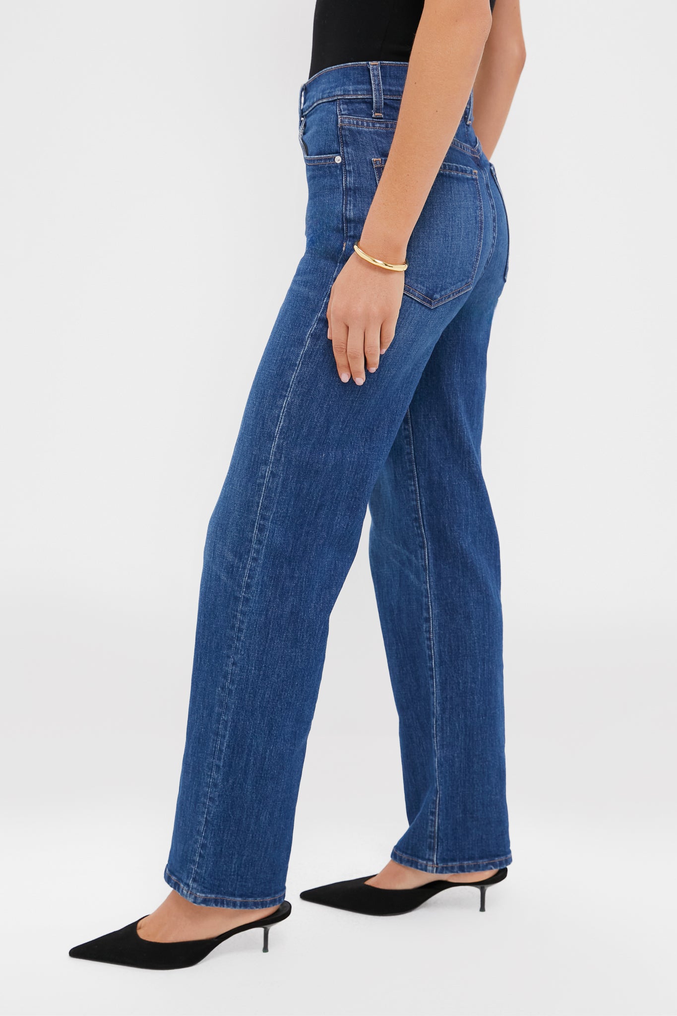 Person wearing Kindred Spirit Mid-High Rise 90's Straight jeans with black slingback mules, showcasing a classic, effortless style. Paired with a gold bangle for a fun, high-end look.