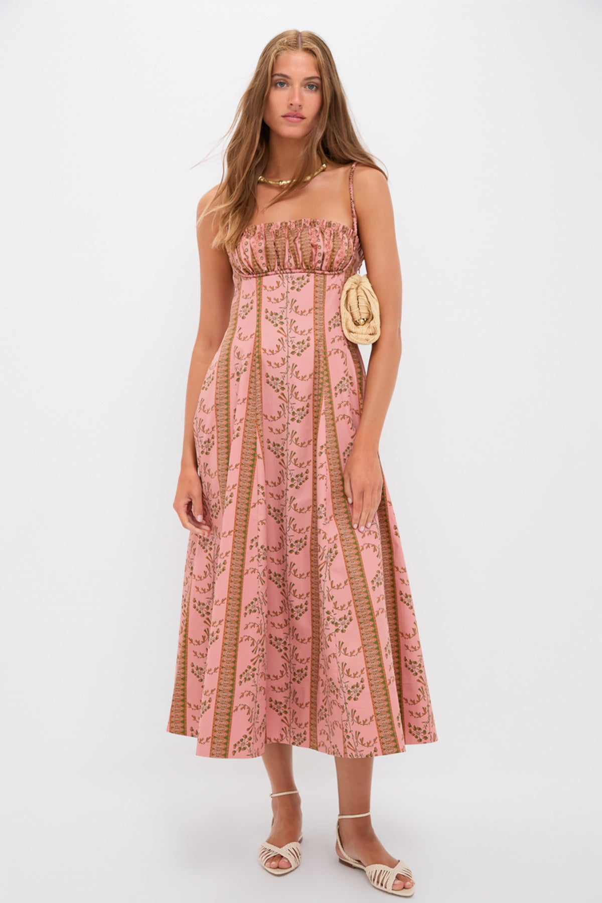 Young woman in a Rust Dandelion Floral Stripe Maisie Dress, a classic midi sundress with ruched bust, showcasing effortless style with fun, high-end accessories.