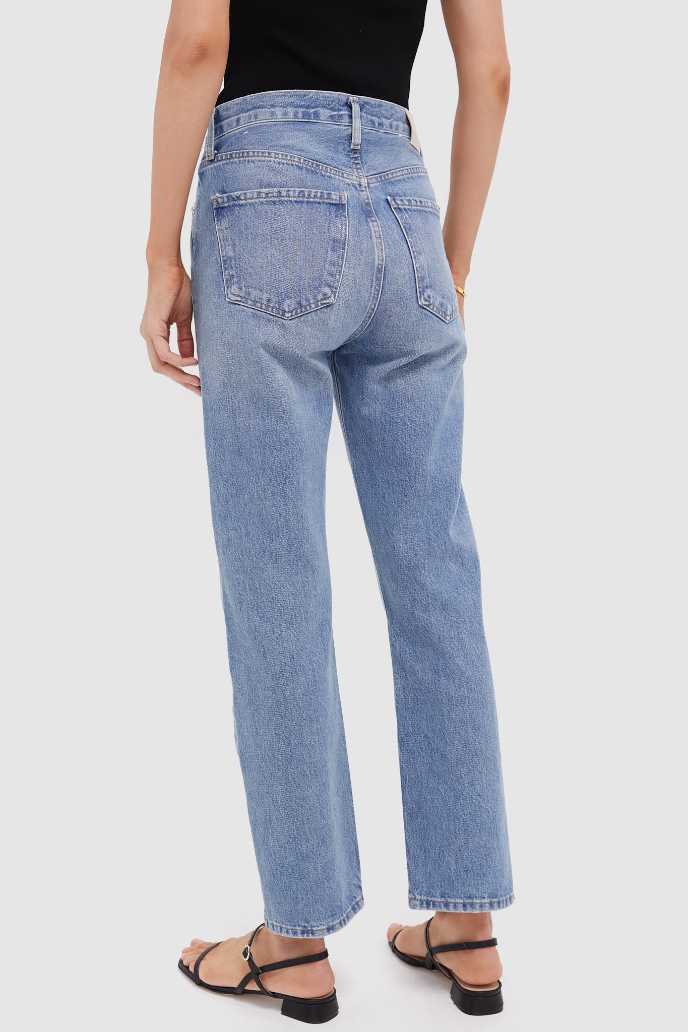 Perri Blaine High Rise Straight jeans showcase classic, effortless style with a high-rise, straight-leg cut, paired with black sandals for a fun, high-end look.