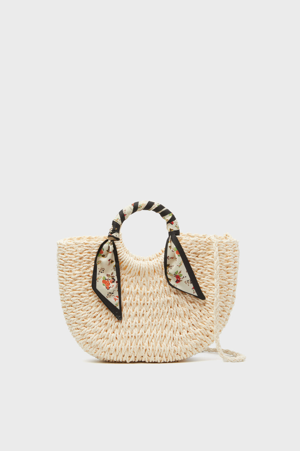 Urban Expressions presents a woven straw bag with round handles wrapped in a floral-patterned scarf and a long shoulder strap—a chic vegan handbag perfect for any occasion.
