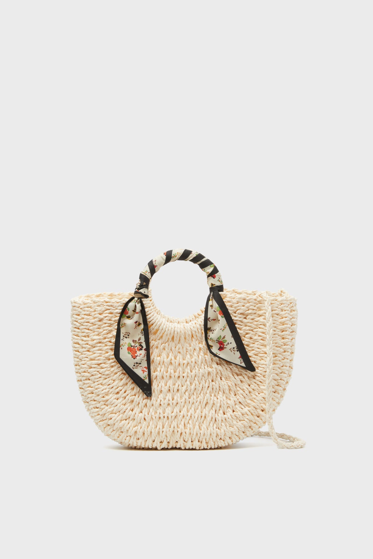 Urban Expressions presents a woven straw bag with round handles wrapped in a floral-patterned scarf and a long shoulder strap—a chic vegan handbag perfect for any occasion.