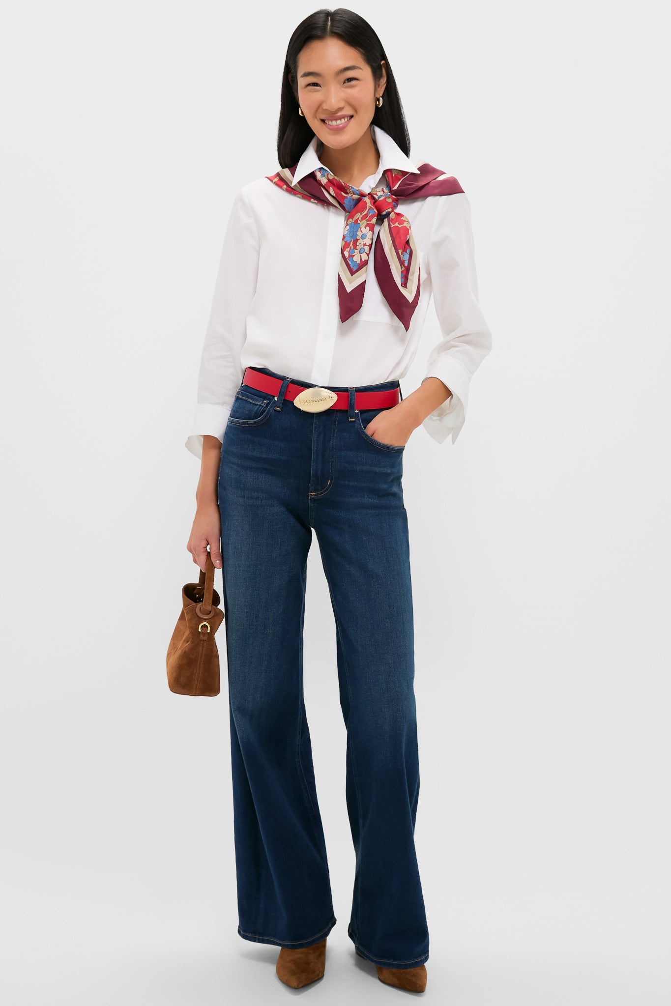 Woman in classic, effortless style with Gold Touchdown Buckle, featuring a football motif, adding fun, high-end flair to her modern, retro-inspired outfit.