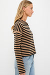 A woman in profile wears Alex Mill essentials: a black and tan striped long-sleeve top and light blue jeans, standing against a plain white background. This timeless, effortless look highlights Alex Mill's classic style.