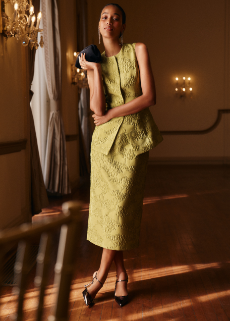 Woman in a matching green vest and skirt. 