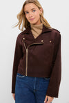 Young woman models the classic Chocolate Faux Suede Bristol Jacket with gold hardware over a tan turtleneck, embodying effortless, high-end style with a fun, chic vibe.