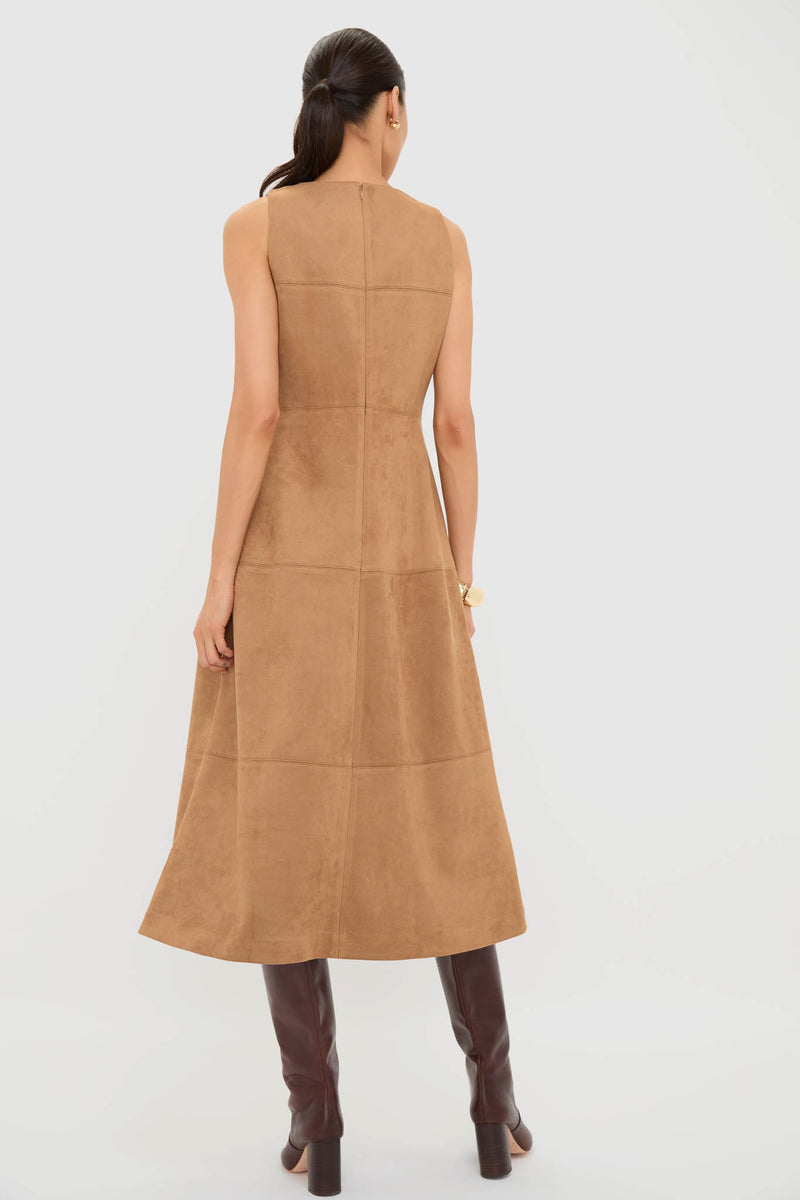 Woman wearing the Buck Vegan Suede Manon Dress, a classic, paneled, midi-length piece styled with effortless dark brown leather boots and fun, high-end gold jewelry.