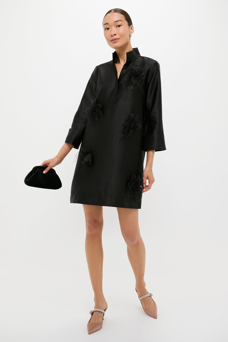 Woman models Mocha Satin Mae Heels, classic pointed-toe mules with a rhinestone strap, styled effortlessly with a loose-fit black dress and velvet clutch.