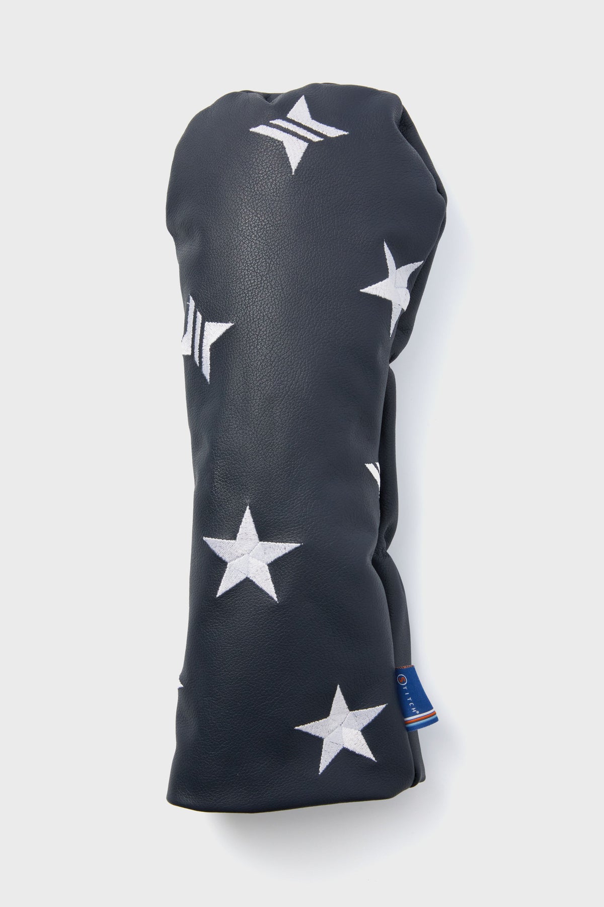 Tuckernuck x Stitch Golf navy leather head cover with white star patterns and a small blue tag near the bottom.