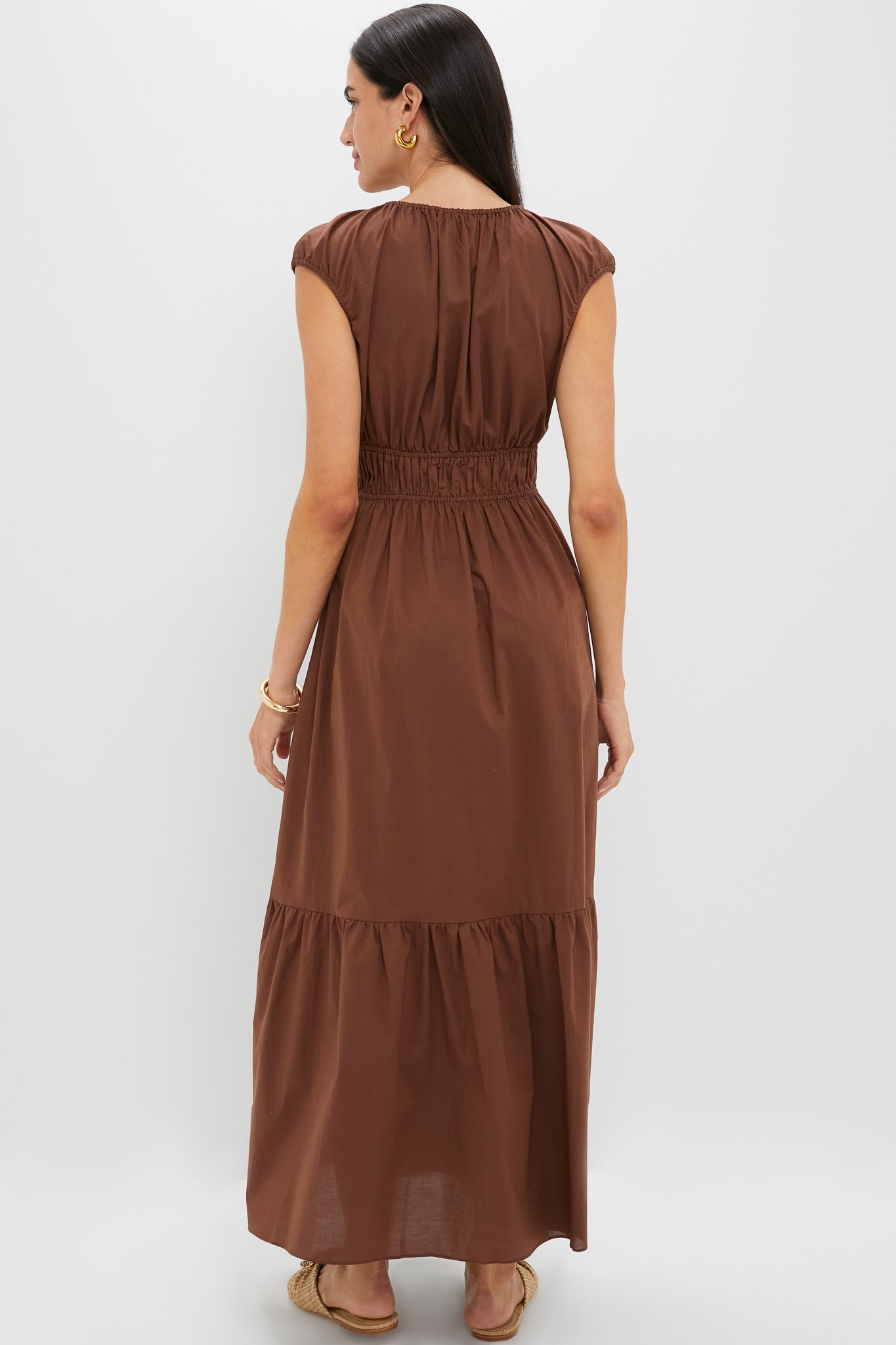 Model in classic Chestnut Brown Hedda Maxi Dress with tiered skirt, showcasing an effortless, high-end look paired with gold accessories and woven sandals for fun, versatile style.