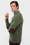 Man wearing the Olive Essential Patch Crew Neck Sweater, featuring classic leather elbow patches over a blue shirt, embodying effortless, high-end style.