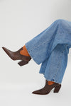 Seal Brown Memphis Boots in light-blue denim, showcasing classic, effortless style. Features include pointed toes, western seams, suede insets, and block heels for fun, high-end appeal.