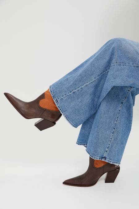 Seal Brown Memphis Boots in light-blue denim, showcasing classic, effortless style. Features include pointed toes, western seams, suede insets, and block heels for fun, high-end appeal.