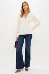 Woman in classic cream blouse and jeans, showcasing Mauve Metallic Mesh Margot Heels with pointed toe and adjustable straps, embodying effortless, high-end style for versatile day-to-night wear.