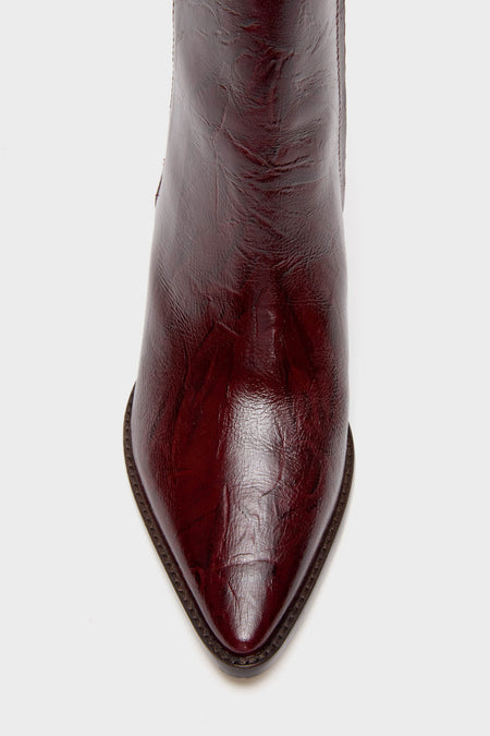 Close-up of the toe on a pointed Matisse boot in burgundy crinkle leather, showcasing its textured finish and visible sole stitching.