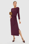 Winetasting Side Tie Elspeth Maxi Dress showcases classic elegance with an effortless faux wrap tie, mid-calf slit, and removable shoulder pads, styled with a suede clutch and T-strap heels.