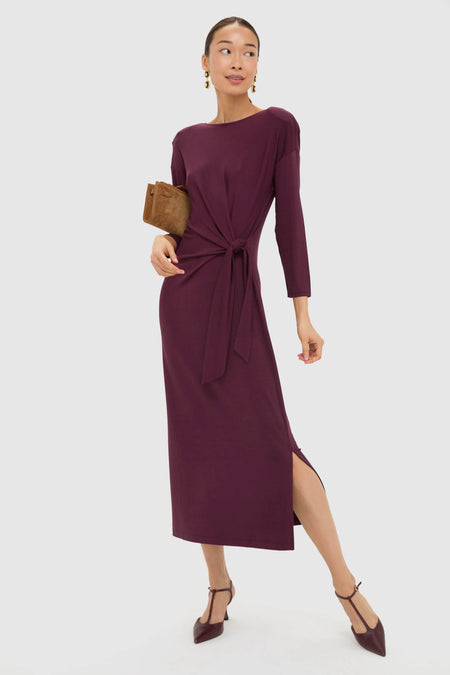 Winetasting Side Tie Elspeth Maxi Dress showcases classic elegance with an effortless faux wrap tie, mid-calf slit, and removable shoulder pads, styled with a suede clutch and T-strap heels.