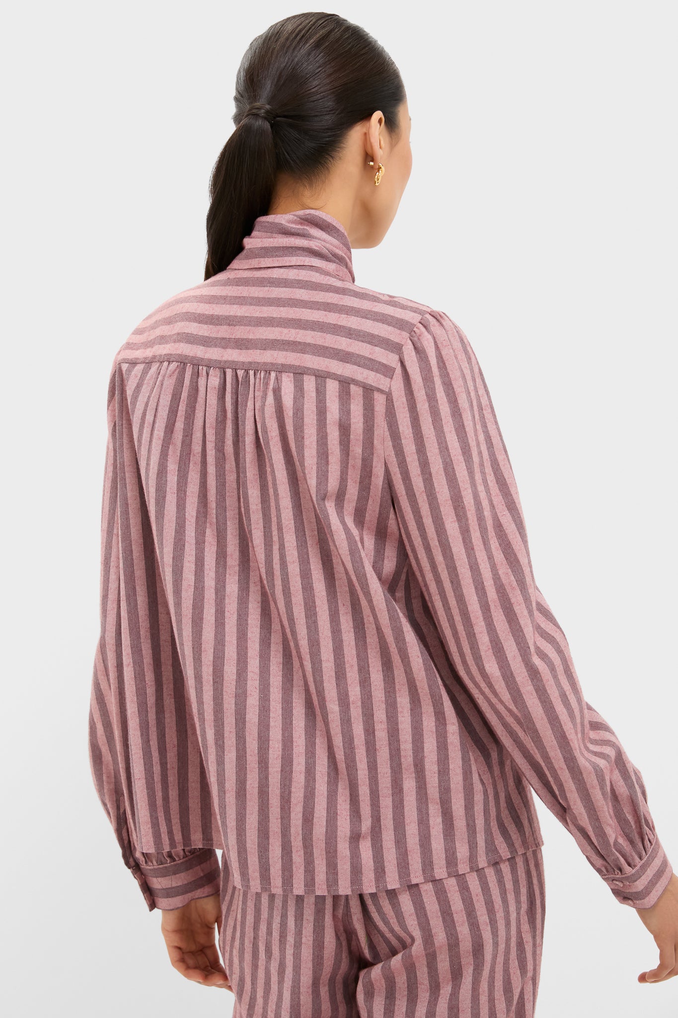 Model wearing the Mauve Stripe Brianna Bow Blouse, showcasing its classic design with an effortless, fun, high-end style; features include a back yoke and gathered detailing.
