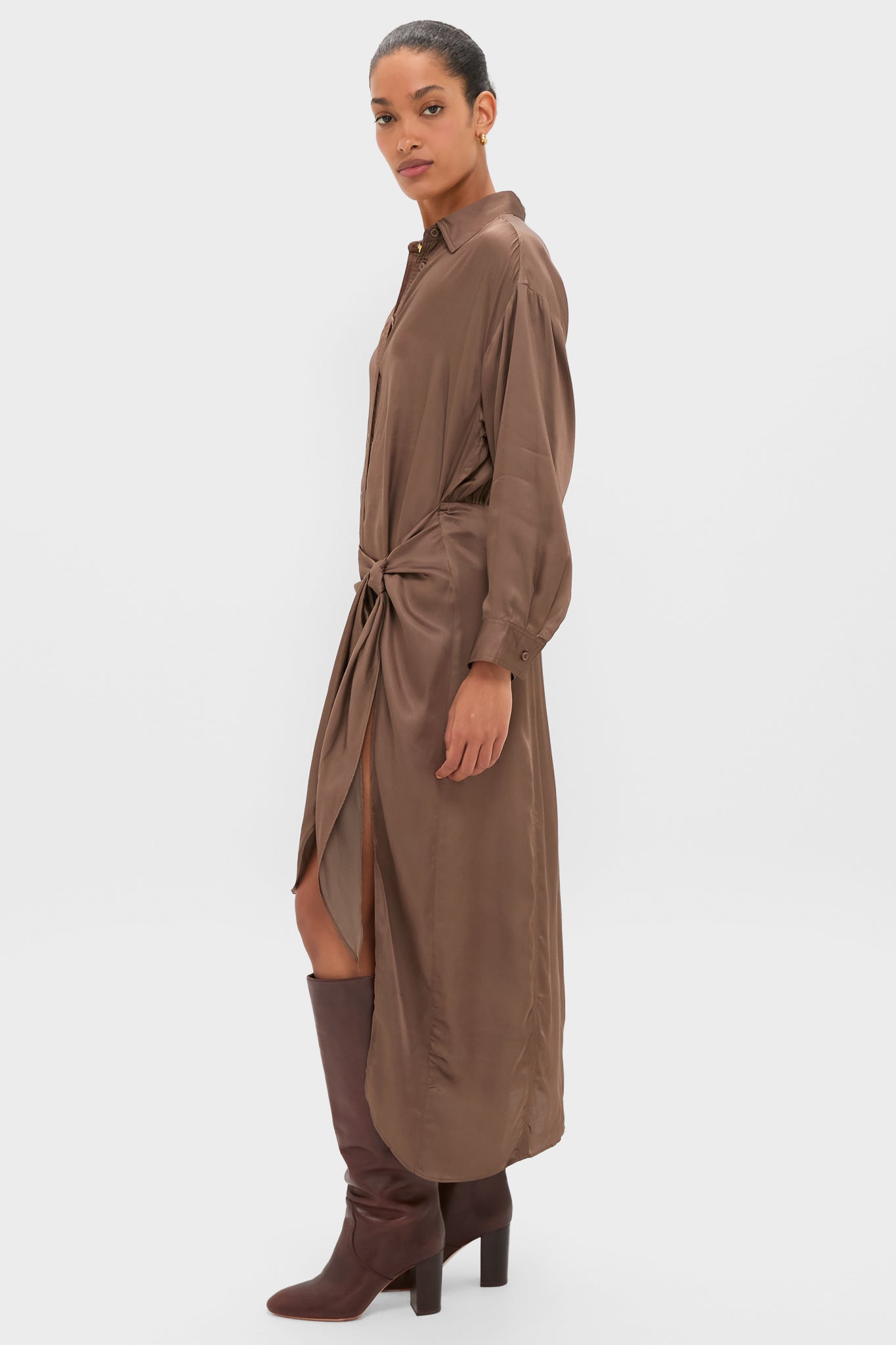 Woman models the Morel Alessandra Sarong Shirt Dress, featuring an effortless, classic silhouette with a knot detail and front slit, paired with high-end, fun mid-calf leather boots.