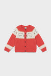 A cozy red knit sweater for children by Bonton, featuring a sheep pattern, cream panels, long sleeves, and a button-up front—perfect for winter and inspired by French kids' fashion.