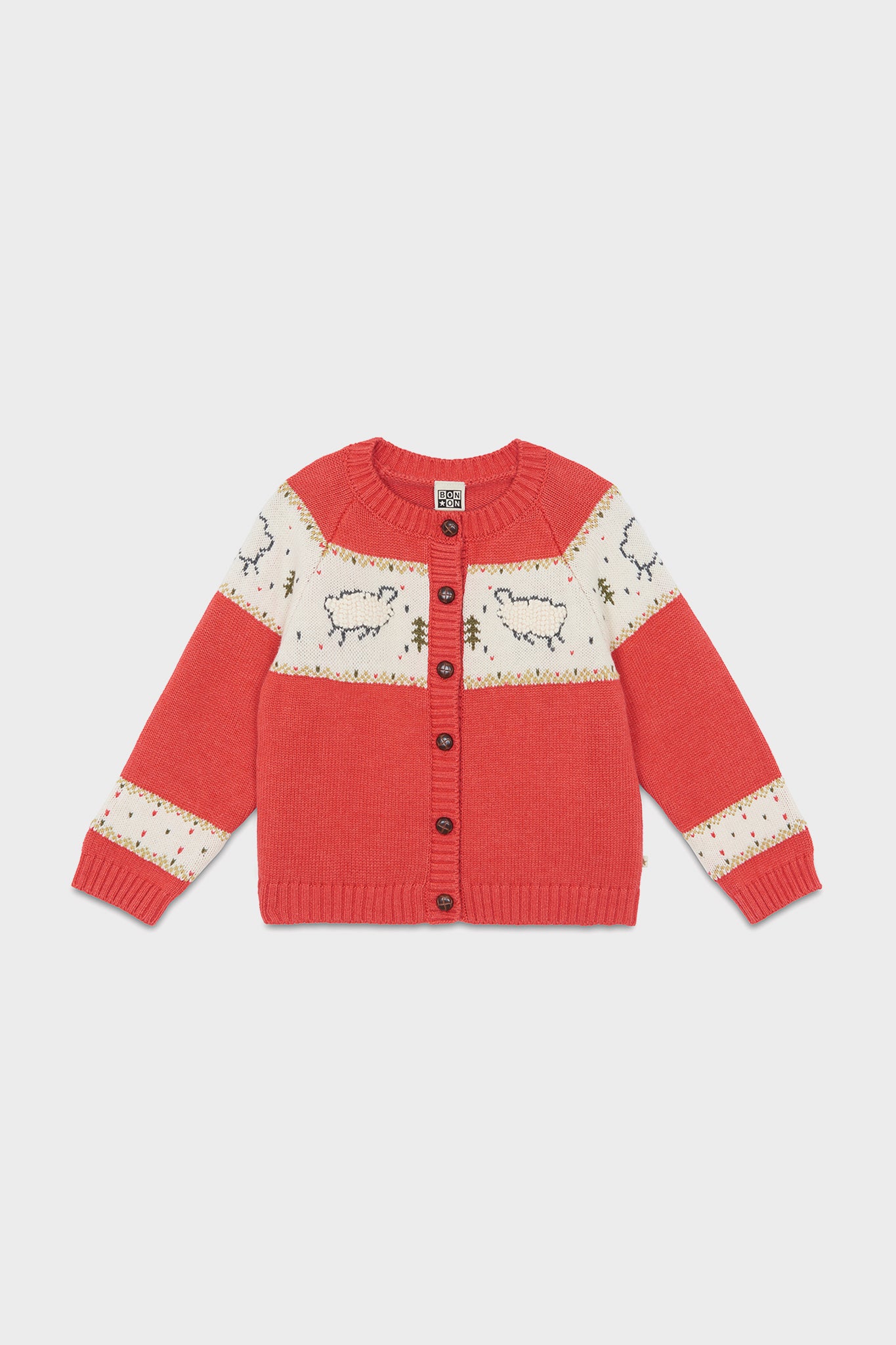 A cozy red knit sweater for children by Bonton, featuring a sheep pattern, cream panels, long sleeves, and a button-up front—perfect for winter and inspired by French kids' fashion.