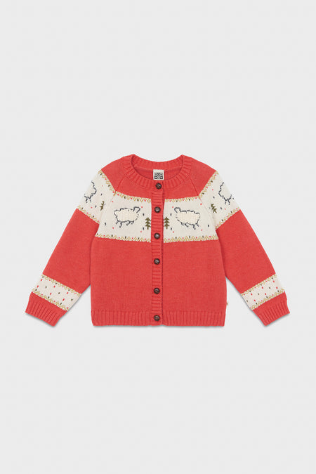 A cozy red knit sweater for children by Bonton, featuring a sheep pattern, cream panels, long sleeves, and a button-up front—perfect for winter and inspired by French kids' fashion.