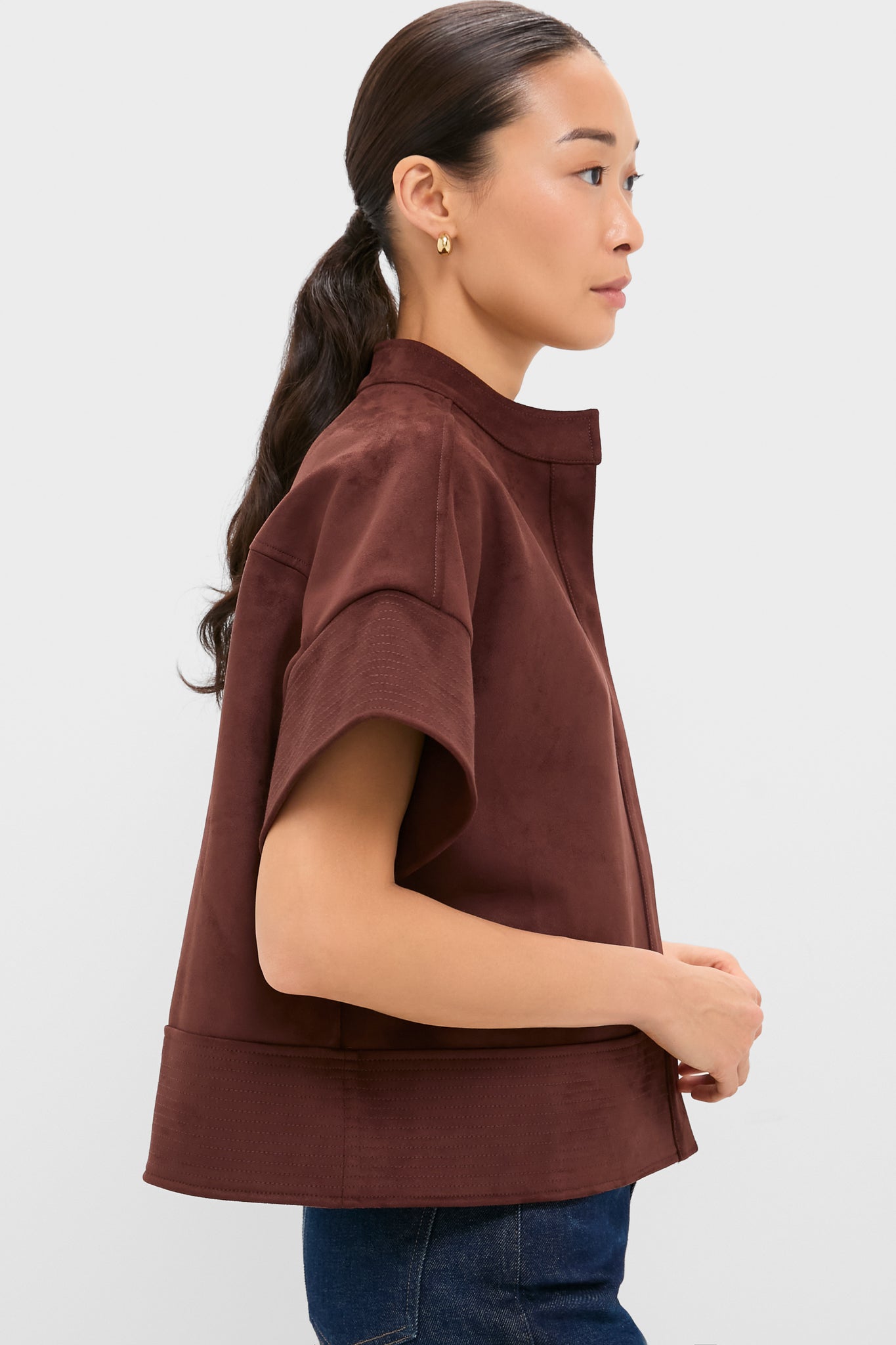 Young woman in Ganache Vegan Suede Trapunto Stitch Sofia Shirt, showcasing its classic, effortless boxy fit and high-end trapunto stitched details, paired with jeans for a fun, versatile look.