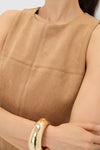 Person wearing the Buck Vegan Suede Manon Dress, showcasing classic seam detailing and an effortless, high-end look. Features a shiny gold bangle for a fun, chic touch.