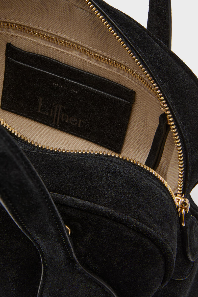 Black Suede Mini Bowling Bag's interior, featuring beige canvas lining, gold-tone zipper, and Liffner-stamped pocket. Classic, effortless, fun design for high-end style.