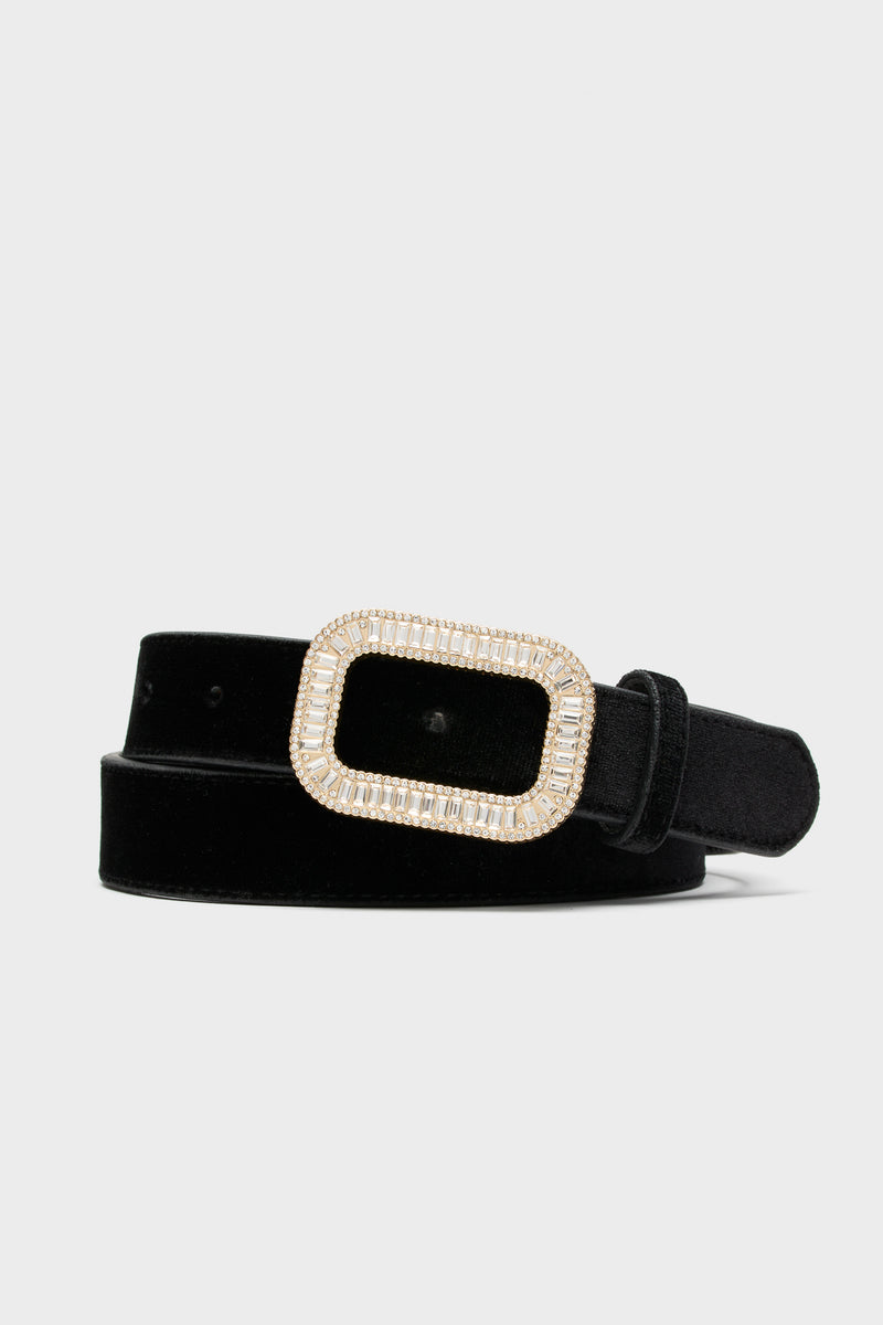 Tuckernuck Accessories presents a black velvet waist belt with an adjustable rectangular gold-tone buckle embellished with clear rhinestones.