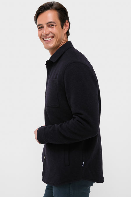 Smiling man in profile wearing the Navy Marl Marlow Tailored Wool Blend Overshirt, showcasing its classic, effortless style with a smart spread collar and double chest pockets.