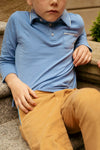Child wearing classic Blue Parker Polo with contrast piping and a patch pocket, paired with tan pants. Effortless, fun style perfect for playground or dinner.