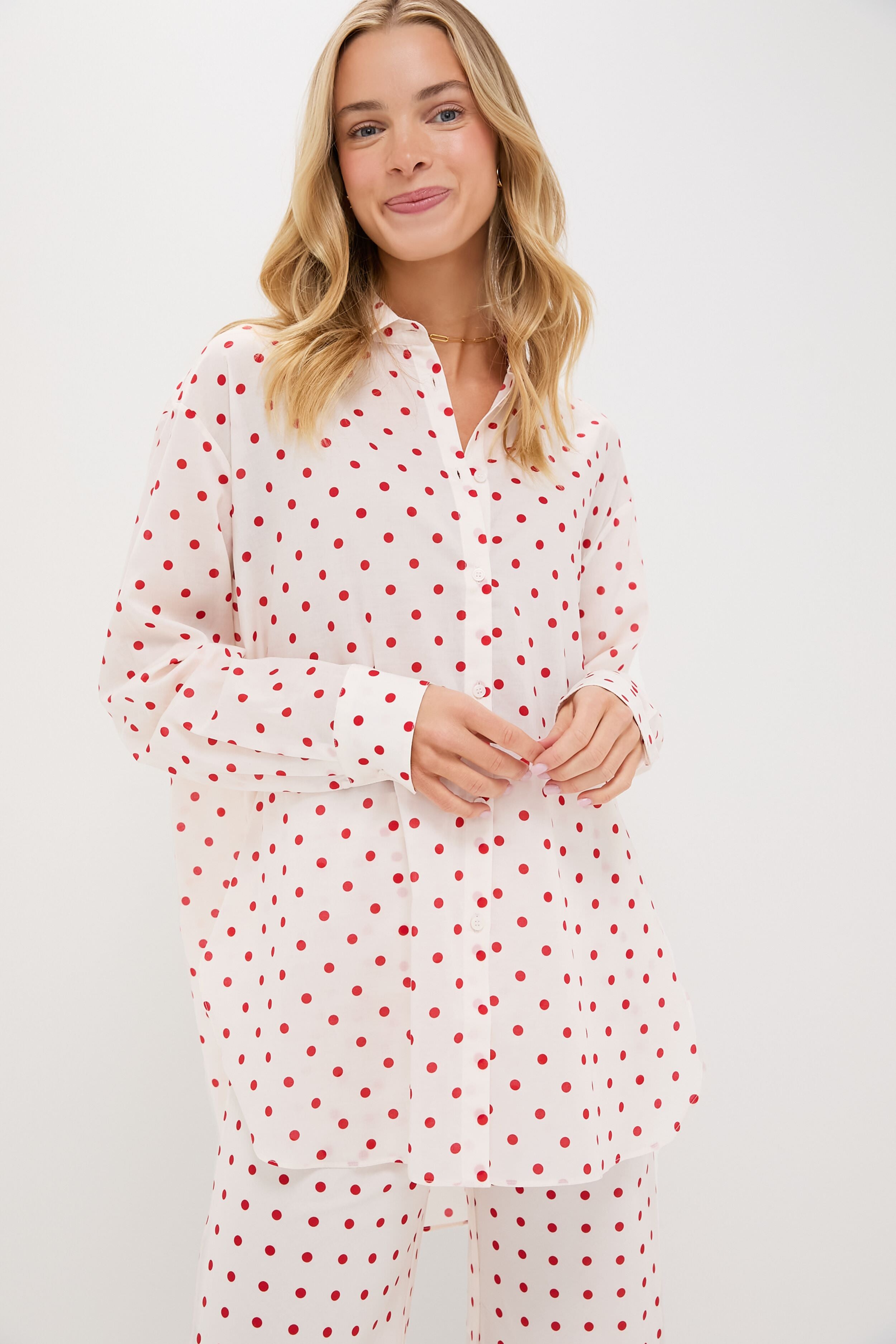 A woman wears a white, oversized fit POSSE shirt and matching pants, both featuring a red polka dot pattern.