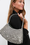 Woman carrying the Covert Foil Rosanna Mini Croce, a classic, effortless hobo-style bag with metallic-silver woven leather, offering a high-end, fun day-to-night style.