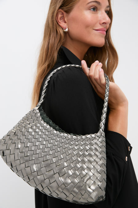Woman carrying the Covert Foil Rosanna Mini Croce, a classic, effortless hobo-style bag with metallic-silver woven leather, offering a high-end, fun day-to-night style.