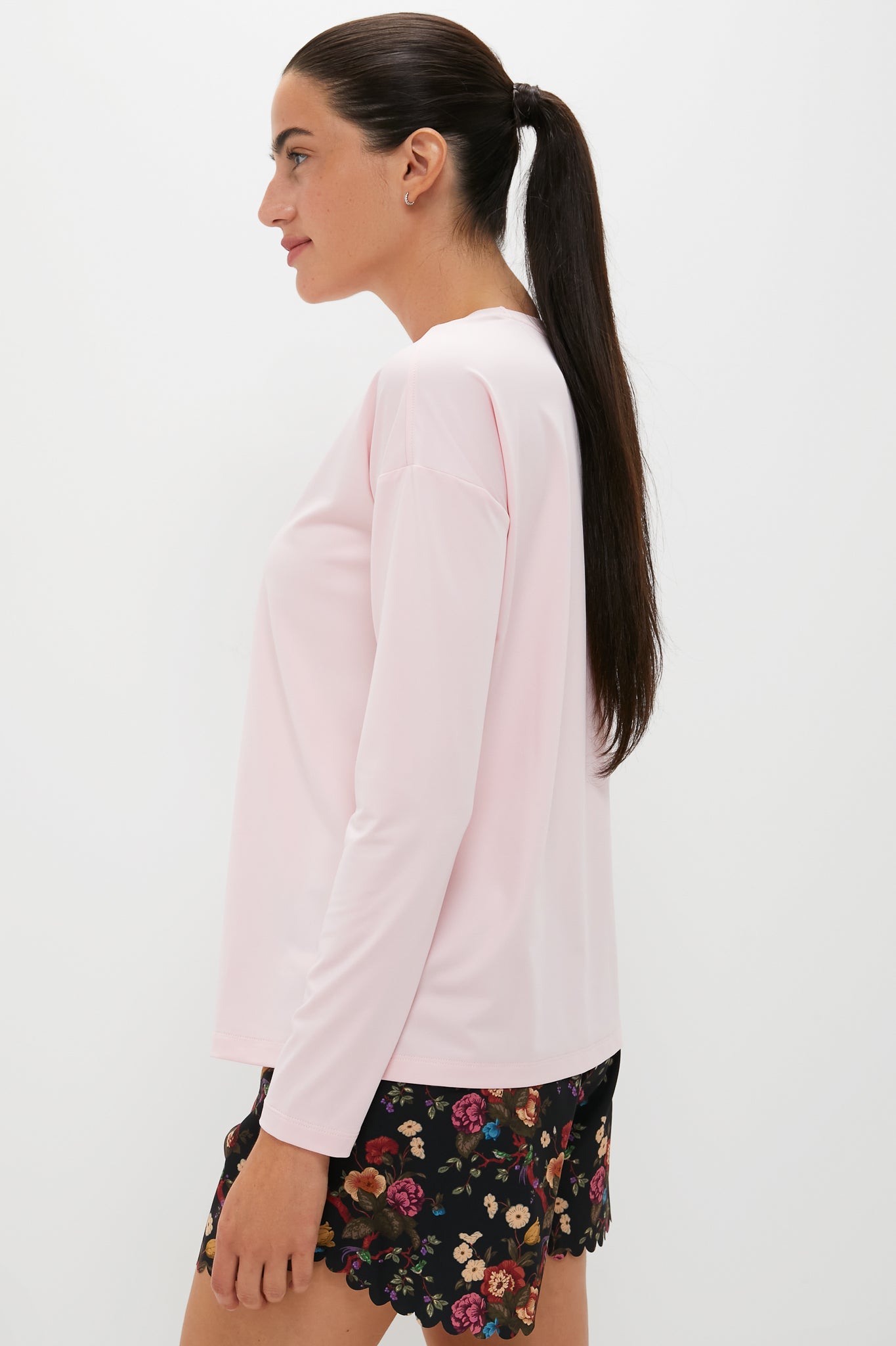 Model wearing the classic Pink Long Sleeve Performance Jersey Ryan Boyfriend Tee, offering an effortless, fun, and high-end look, styled with floral shorts.