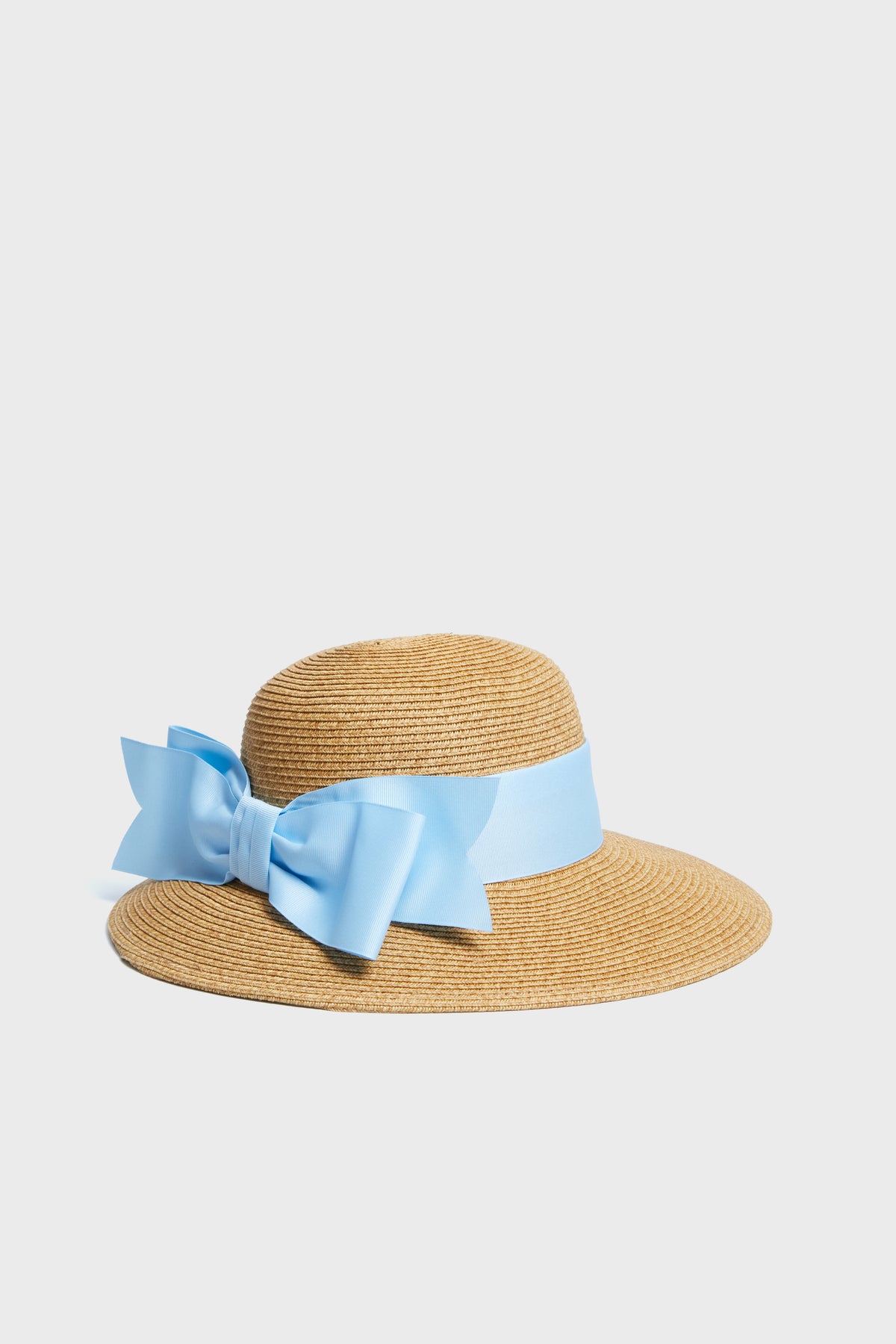 Toucan Hats wide brim straw hat with a light blue ribbon and bow is a stylish, packable essential for sunny days and beach outings.