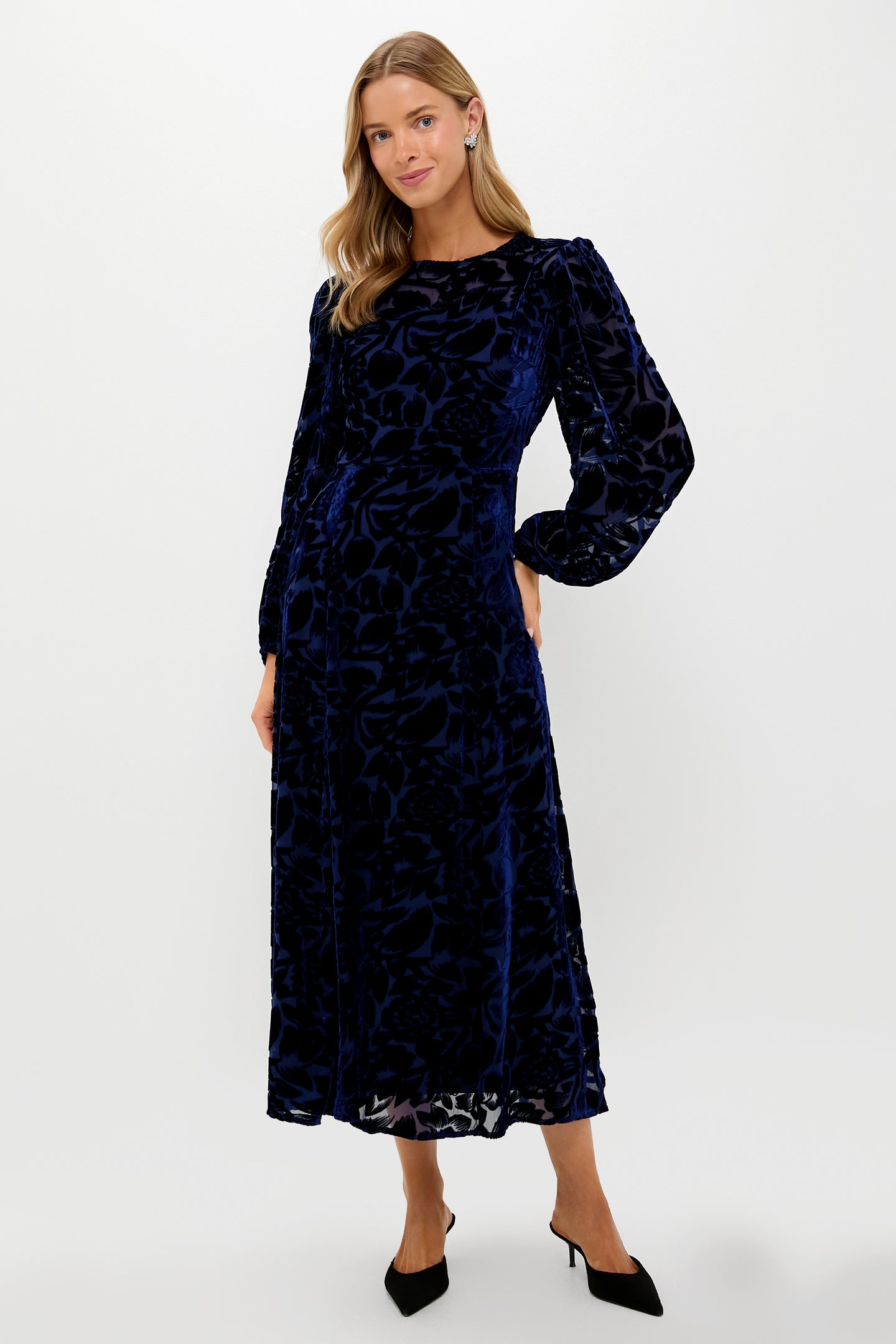 A woman wears the Hyacinth House navy blue velvet floral maxi dress with long sleeves and ankle-length design, perfect for a wedding guest.