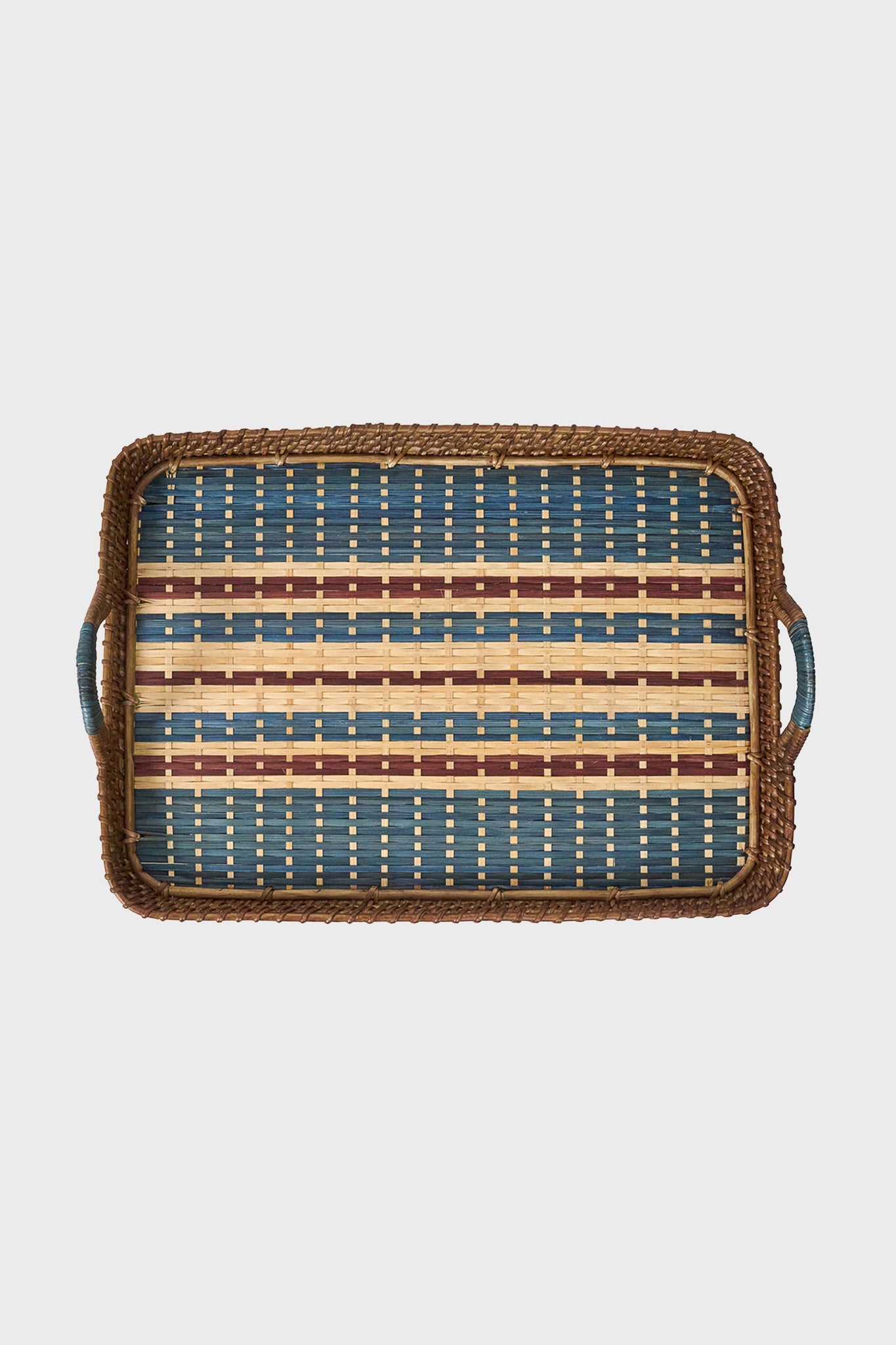 Juliska rectangular handwoven serving tray with blue, yellow, and brown stripes, side handles, and Scandinavian design, crafted from natural cane wood.