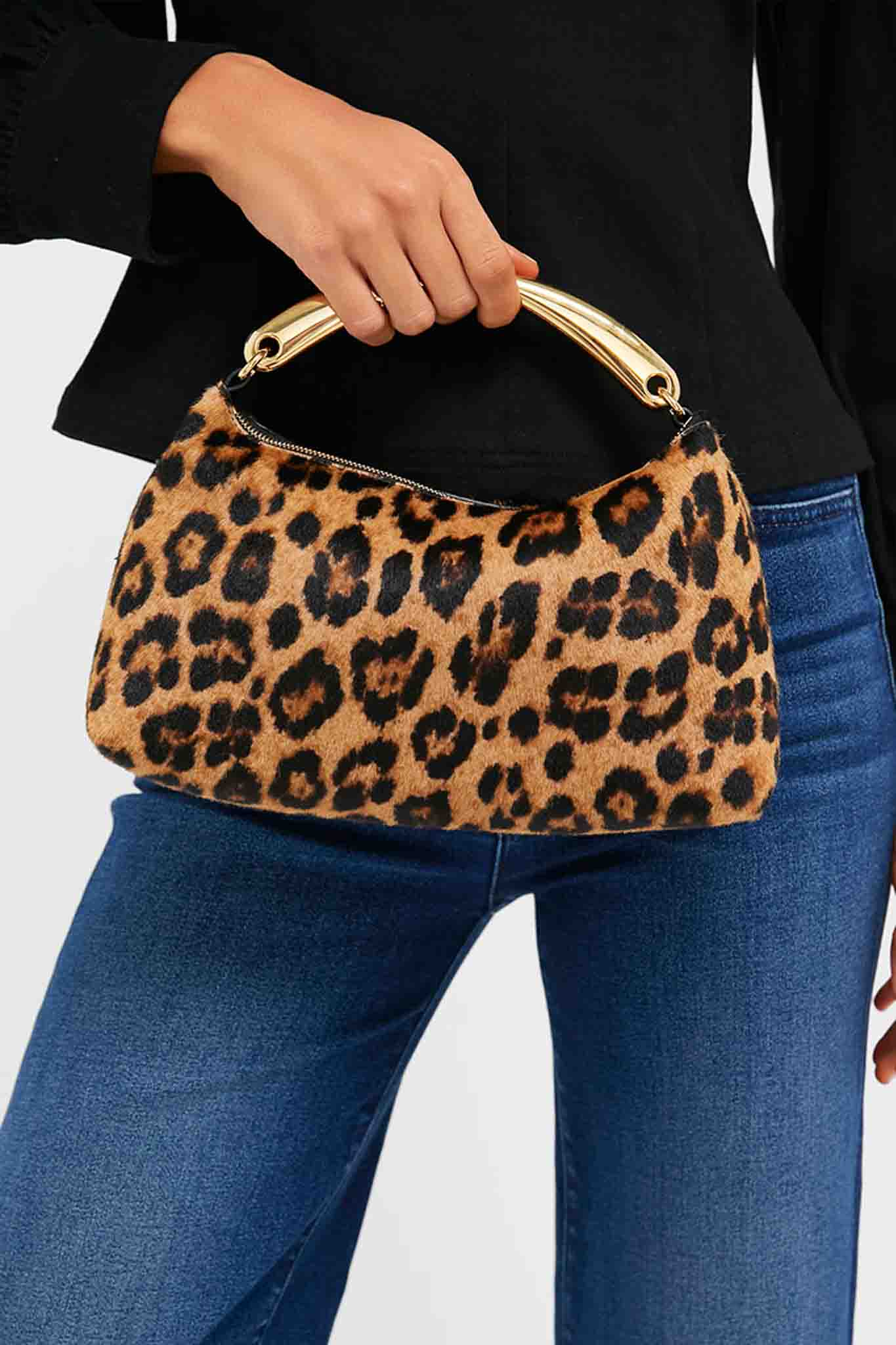 Woman holding the Leopard Metal Handle Rhea Bag—a classic, high-end handbag with a leopard-print faux-fur finish and sleek gold handle, offering an effortless, fun style.