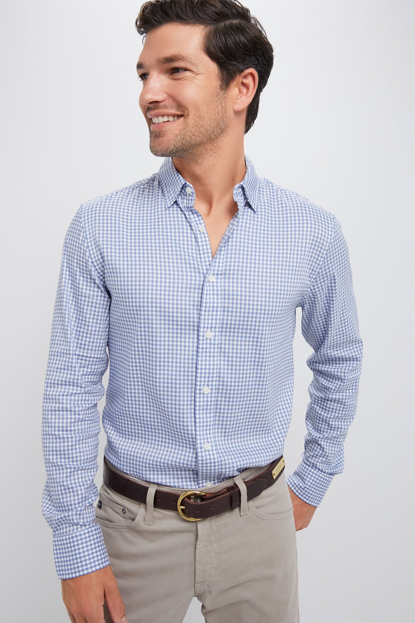 Model in classic Light Blue Gingham Movement Shirt, effortlessly styled with khaki trousers and a dark brown belt, exuding fun and high-end surf culture-inspired fashion.