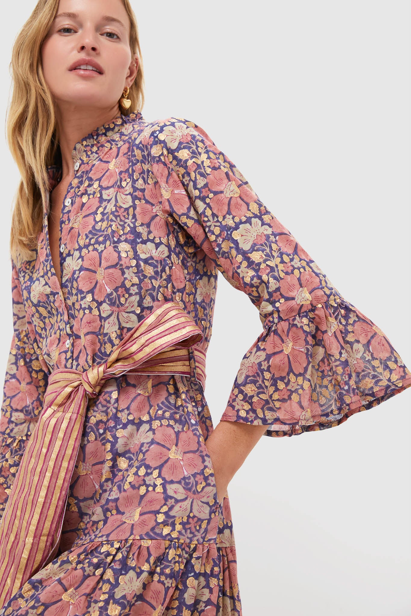 Woman in Matera Navy Ruffle Collar Bell Maxi Dress with classic floral print, ruffled sleeves, and a tied belt, embodying an effortless, high-end style.