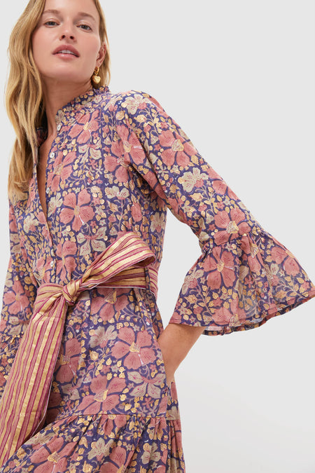 Woman in Matera Navy Ruffle Collar Bell Maxi Dress with classic floral print, ruffled sleeves, and a tied belt, embodying an effortless, high-end style.